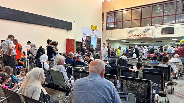 People wait to be processed at the Rafah crossing