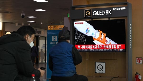 People in Seoul watch a television screen showing a news broadcast of North Korea's latest rocket launch